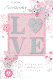 The anniversary card shown here offers a gentle tribute to enduring romance, its design echoing the soft pastels of a spring bouquet delivered around Gants Hill. At its centre, the word LOVE appears in raised, softly rounded letters coated with fine, shimmering glitter. The colours within the letters move between delicate blush pink and pearly off-white, edged with a thin halo of silver sparkle, making the word stand out with a subtle glow. The O is reimagined as a sparkling, silver-textured heart, giving the design a focal point that feels both playful and sincere. This central motif rests on a blush-pink background panel, set against a slightly brighter, almost luminous white field. Around it, an array of illustrated flowers opens in shades of blush, mauve, and pale grey. Their outlines are drawn with light, sweeping strokes, suggesting a loose, watercolour softness rather than rigid shapes, akin to the organic style often used by Gants Hill Florist for romantic arrangements. Fine trailing vines and swirling lines weave between the blossoms, while tiny butterflies, petals, and flourishes seem to drift around them, adding a sense of quiet motion. Near the top and bottom of the design, the sentiments On Our Anniversary and I love you today and always appear in refined, flowing script, the lettering slender but clearly legible. Together, the pastel palette, silver highlights, and airy floral motifs create an atmosphere of intimacy and gratitude, ideal for celebrating the shared journey of a couple in Gants Hill on their special day.